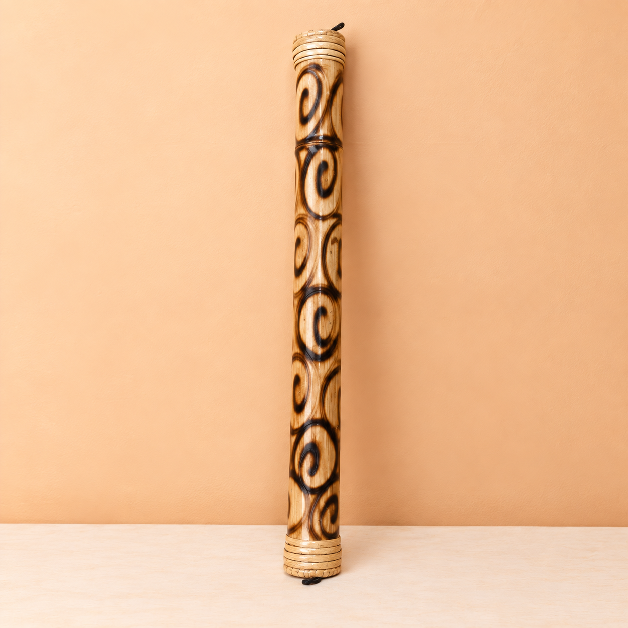 Polished Wooden Didgeridoo Against Peach Wall